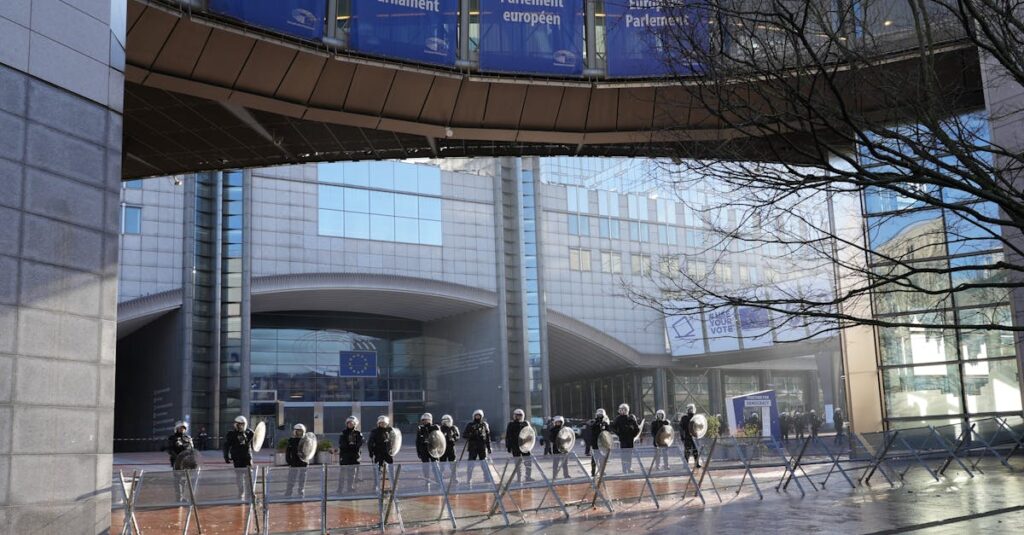 Police officers stand guard outside the European Parliament building in Brussels, Belgium.