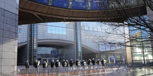 Police officers stand guard outside the European Parliament building in Brussels, Belgium.