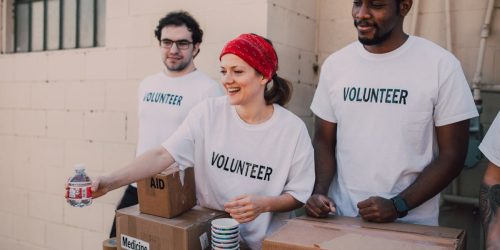 Volunteers distributing aid at an outdoor donation center, promoting social impact and diversity.